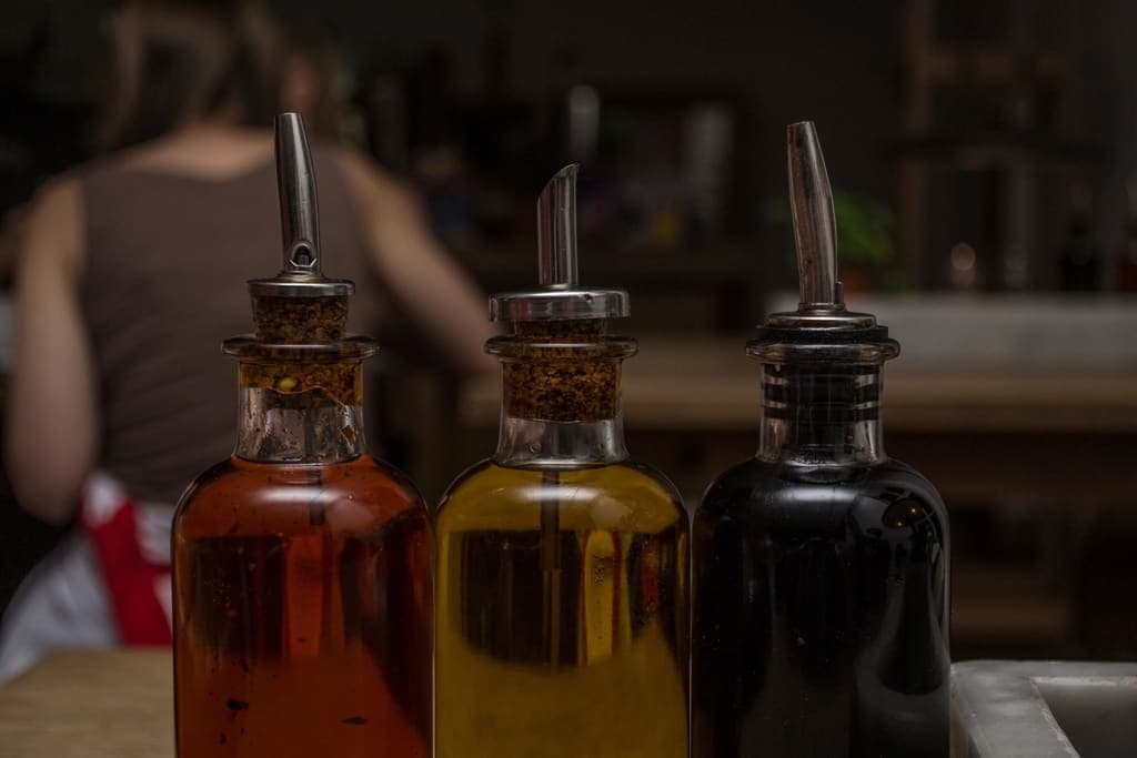 Ampolle di olio con il beccuccio su uno scaffale
